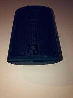 Front angled view of one black Acoustic Research surround speaker showing mesh grille and logo badge