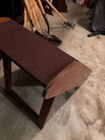 Wood dog step on a concrete floor, showing the angled front and brown non-slip top surface.