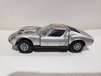 Side view of silver Lamborghini Miura P400 diecast car showing wear and paint chipping on body and roof