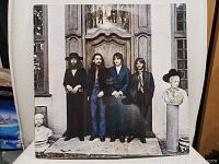 Front cover of The Beatles Hey Jude vinyl album showing the four band members standing in front of a wooden door with sculptures on both sides.