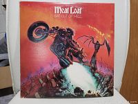 Front cover of Meat Loaf Bat Out Of Hell vinyl record showing artwork of motorcycle rider and fiery scene
