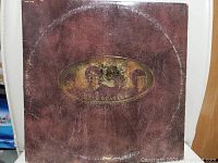 Front cover of The Beatles Love Songs vinyl record with a brown leather-look design and a gold oval logo featuring the band.