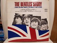 Front cover of The Beatles Story vinyl records album sleeve featuring black and white photo of all four Beatles and a Union Jack flag graphic