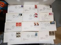 Photo showing all 12 envelopes with first day of issue stamps laid out in a grid