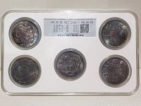 Front view of five Chinese silver coins in graded plastic case showing dragon and character designs.
