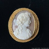 Front view of oval shell cameo carved profile of classical maiden in 18K gold frame
