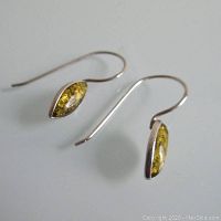 Pair of silver earrings with amber stones displayed against white background, showing shape, color and hook style.