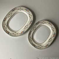 Top view of two oval Mintons porcelain platters showing overall pattern and condition.