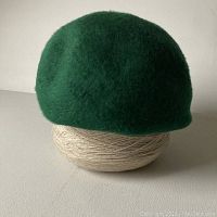 Front and side view of the bright green beaver fur hat showing the texture and shape.