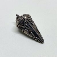 Side view of the silver Celtic knot locket showing the intricate knotwork and heart motifs with the bail at the top.