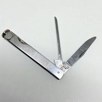 Image showing the pocket knife opened with the blade and pipe cleaning tool extended, displaying the 'Keen Edge Japan Stainless Steel' stamp on the blade.