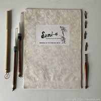 Sumi-e paper pad, calligraphy pen nib holder with four nibs, and two brushes