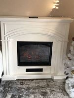 Front view of assembled white mantel with electric firebox insert and active flame effect