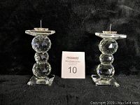 Both Swarovski crystal candle holders side by side on black background with a MaxSold number card.