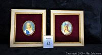 Two framed oval portrait plaques on burgundy velvet showing women in historical dress, framed in cream and gold with visible wear.