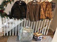 Three jackets hung on railing with two packaged bedding sets below