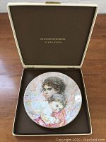 Collector's plate in its original presentation box showing the plate centered in a brown box.