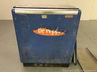 Front view showing blue body, faded Dr. Pepper front graphic with scratches and wear.