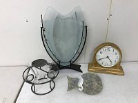 Three vases and a desk clock arranged against a white wall showing overall lot contents