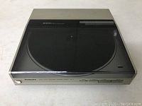 Top view of Technics SL-5 turntable with closed transparent dust cover, showing the record platter underneath and the unit's silver exterior.