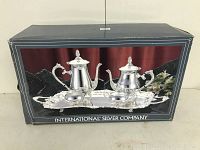 Box displaying the full International Silver Company coffee and tea service set with tray, coffee pot, and tea pot shown.