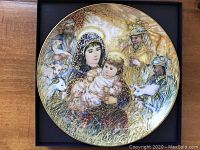 Front view of the collector's plate featuring The Adoration of the Shepherds scene with Mary, baby Jesus, shepherds and animals in vibrant colors and gold accents.