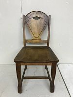 Front view of vintage wooden kitchen chair showing seat and legs.