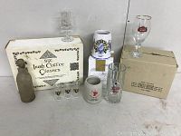 Lot of Irish coffee glasses, box for six glasses, and an antique bottle with string on neck in dusty condition.