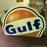 Front view of large molded plastic Gulf Gasoline sign with raised blue letters on orange background.