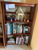 Front view of the mission style wooden bookcase filled with books and decorative items (contents not included).