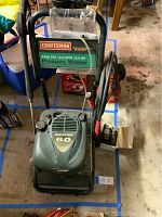 Front view showing Craftsman logo, pressure and flow rating 2300 PSI / 2.0 GPM, 6.0 HP Quantum Gold engine label, hose coiled on handle.