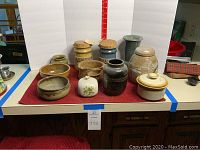 Group view of all ten pottery pieces arranged on countertop