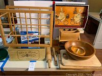Overall photo of multiple wooden kitchen items including cutting boards, rolling pin, utensil holder, wooden bowls, and racks
