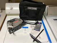 Craftsman Orbital Sabre Saw with black Craftsman carrying bag, instruction manual, extra Bosch blades, and blade changing tool arranged on white surface.