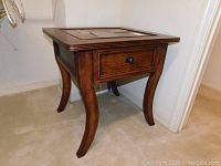 Photo of Ashley Millennium end table showing curved legs and drawer closed