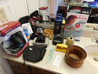 Photo showing all items together on a bathroom counter including heating pad box, blood pressure monitor box, grooming kits, wooden bowl, and toothbrush holder