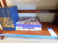 Three-volume boxed set of The Complete Letters of Vincent Van Gogh in blue slipcase with gold decoration placed on a wooden shelf alongside three additional hardcover books.