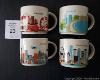 Front view showing the colorful cityscape designs and city names on each of the four Starbucks You Are Here mugs.