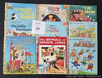 Photo of all nine Little Golden Books arranged flat showing front covers, titles, and condition.