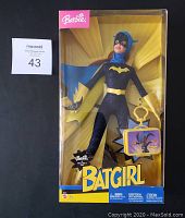Front view of the sealed Batgirl Barbie doll in its yellow packaging with Batgirl logo and Mattel logo visible