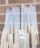 Clear acrylic posts/rods displayed against a brick wall, showing their transparency and cylindrical shape.