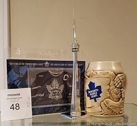 Photo showing all three items: Maple Leafs stein, framed Canada Post stamp, and CN Tower model