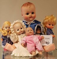 Group photo of all six dolls showing various styles and sizes, highlighting the vintage Regal Canada doll in blue.