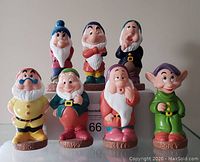 Seven colorful rubber squeak toys of the Seven Dwarfs, front view, showing details of faces and clothes.