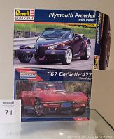 Front view of both model car kit boxes stacked, showing the Revell Monogram Plymouth Prowler with Trailer on top and the '67 Corvette 427 Roadster below, with clear box art featuring the cars.