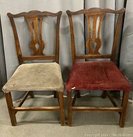 Front view of the pair of early country Chippendale style chairs, showing carved backs and differently upholstered seats (beige and red).