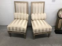 Pair of Italian style side chairs with carved wooden frames and striped fabric upholstery. Includes seat, back cushions and bolster pillows.