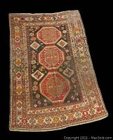 Overview of the full rug showing geometric patterns and overall condition