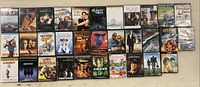 Full view of 32 DVD cases arranged in four rows showing movie titles and cover art.