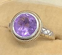 Front view showing the round cut amethyst set within a 14K gold halo and sterling silver band.